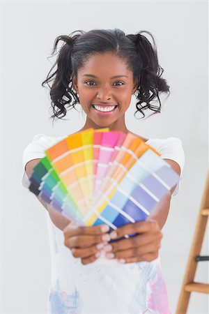 simsearch:400-07834992,k - Excited woman showing colour charts against a blank wall Fotografie stock - Microstock e Abbonamento, Codice: 400-06891489