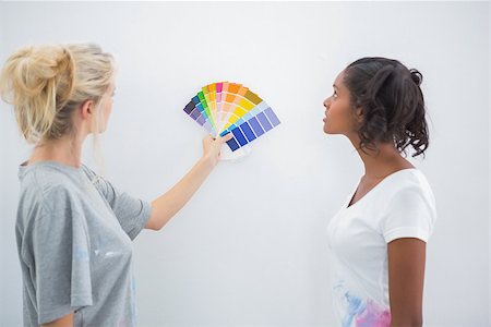 simsearch:400-07834992,k - Housemates picking colour for blank wall in their new home Fotografie stock - Microstock e Abbonamento, Codice: 400-06891509