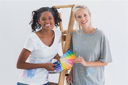 simsearch:400-07834992,k - Friendly housemates choosing colour for wall looking at camera in their new home Fotografie stock - Microstock e Abbonamento, Codice: 400-06891500