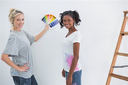 simsearch:400-07834992,k - Housemates picking colour for blank wall and smiling at camera in their new home Fotografie stock - Microstock e Abbonamento, Codice: 400-06891510