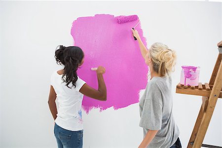 simsearch:400-07834992,k - Happy young housemates painting wall pink in their new home Fotografie stock - Microstock e Abbonamento, Codice: 400-06891528