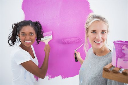 simsearch:400-07834992,k - Cheerful young housemates painting wall pink in their new home and looking at camera Fotografie stock - Microstock e Abbonamento, Codice: 400-06891530