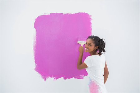 Smiling woman painting her wall in bright pink and looking at camera Stock Photo - Budget Royalty-Free & Subscription, Code: 400-06891547
