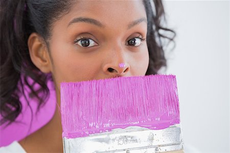 Pretty woman holding paintbrush with pink paint on her nose looking at camera Photographie de stock - Aubaine LD & Abonnement, Code: 400-06891554