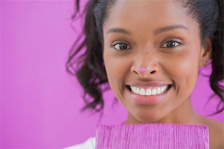 simsearch:400-07834992,k - Happy woman holding paintbrush with pink paint on her nose smiling at camera Fotografie stock - Microstock e Abbonamento, Codice: 400-06891551