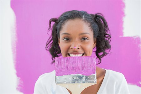 Young woman holding paintbrush with pink paint on her nose smiling at camera Photographie de stock - Aubaine LD & Abonnement, Code: 400-06891553