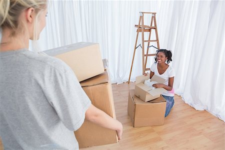 simsearch:400-07834992,k - Happy friends unpacking moving boxes in their new home Fotografie stock - Microstock e Abbonamento, Codice: 400-06891561