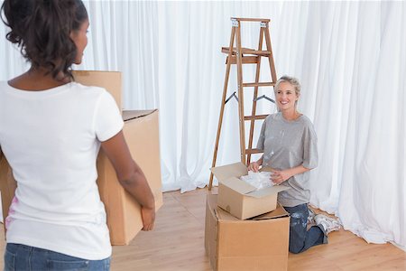 simsearch:400-07834992,k - Young friends unpacking moving boxes in their new home Fotografie stock - Microstock e Abbonamento, Codice: 400-06891563
