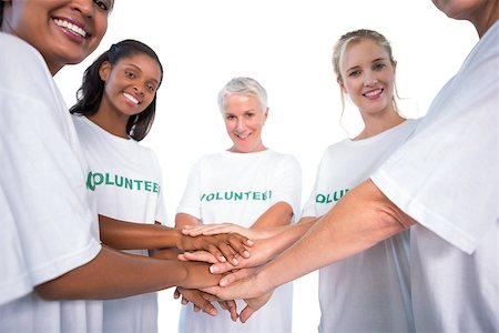 Group of female volunteers with hands together smiling at camera on white background Photographie de stock - Aubaine LD & Abonnement, Code: 400-06891634