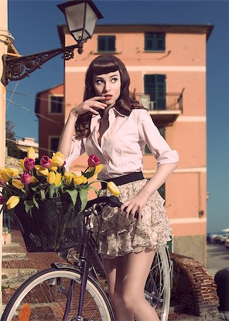 retro pin up girls - portrait of sensual fashion female with vintage style posing near bicycle and basket with colourful flowers. She wearing pink shirt and very short skirt Photographie de stock - Aubaine LD & Abonnement, Code: 400-06891829