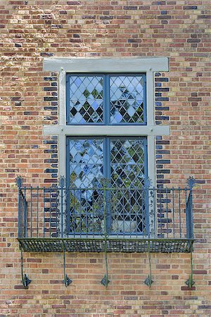 Tudor Style Windows with Rod Iron Scrollwork Metal Balcony on Exterior Brick Wall Stock Photo - Budget Royalty-Free & Subscription, Code: 400-06892427