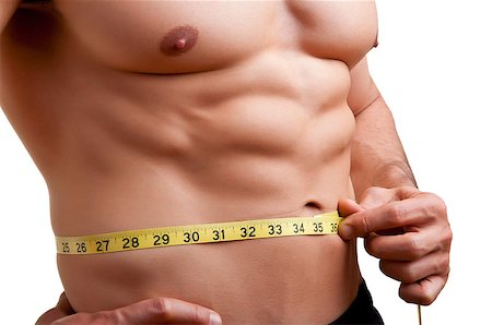 Fit man measuring his waist after a workout in the gym, isolated in a white background Stock Photo - Budget Royalty-Free & Subscription, Code: 400-06914119