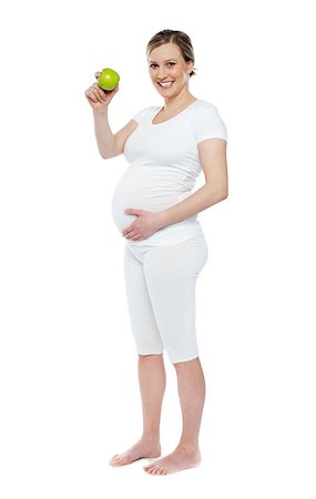 Pregnant woman showing fresh green apple while holding her belly. Isolated over white background Stock Photo - Budget Royalty-Free & Subscription, Code: 400-06914803