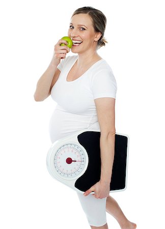 Young pregnant woman enjoy fresh green apple and holding weighing scale in other hand hand Stock Photo - Budget Royalty-Free & Subscription, Code: 400-06914848