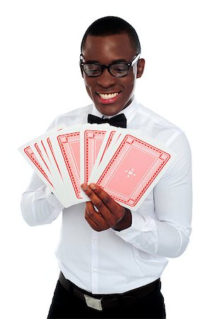 A young black man holding and looking out deck of cards on white background Stock Photo - Budget Royalty-Free & Subscription, Code: 400-06914875