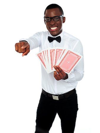Gambler with playing cards pointing at you isolated over white background Stock Photo - Budget Royalty-Free & Subscription, Code: 400-06914878