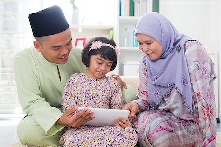 Southeast Asian family using tablet pc computer at home. Muslim family living lifestyle. Happy smiling Malay parents and child. Stock Photo - Budget Royalty-Free & Subscription, Code: 400-06915029