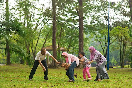 family healthy candid - Muslim family having fun at green outdoor park. Beautiful Southeast Asian family playing together. Stock Photo - Budget Royalty-Free & Subscription, Code: 400-06915049