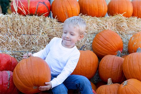 simsearch:400-07169847,k - cute caucasian boy holding a big pumpkin at pumpkin patch Photographie de stock - Aubaine LD & Abonnement, Code: 400-06917023