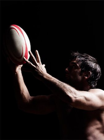 one caucasian sexy topless man portrait hugging a rugby ball on studio black background Stock Photo - Budget Royalty-Free & Subscription, Code: 400-06917819