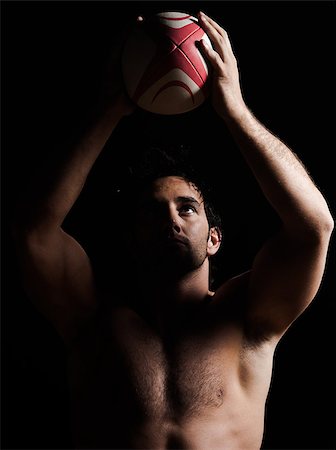 one caucasian sexy topless man portrait tossing a rugby ball on studio black background Stock Photo - Budget Royalty-Free & Subscription, Code: 400-06917857