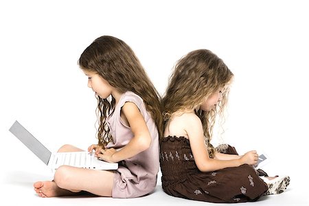 caucasian little girls playing game console back to back isolated studio on white background Stock Photo - Budget Royalty-Free & Subscription, Code: 400-06917893