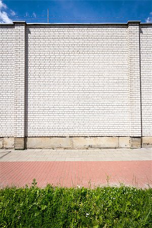 simsearch:400-06892144,k - Empty brick wall with a copy space also showing sidewalk, grass and sky Stockbilder - Microstock & Abonnement, Bildnummer: 400-06918729