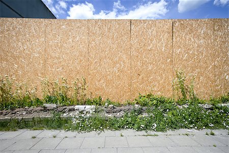 street with city background - Empty chipboard fence with a copy space also showing sidewalk, grass and sky Stock Photo - Budget Royalty-Free & Subscription, Code: 400-06918730