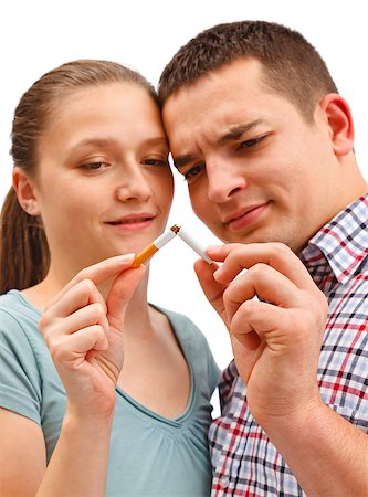 Young couple breaking apart cigarette, meaning stop smoking. Warning: focus on cigarette! Stock Photo - Budget Royalty-Free & Subscription, Code: 400-06912570