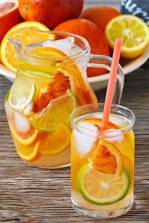 fresh glass of ice water - Jug oh fresh cold citrus lenonade with ice cubes on a wooden background. Stock Photo - Budget Royalty-Free & Subscription, Code: 400-06913266