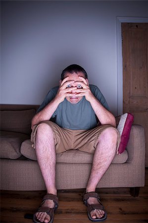 single man on the couch watching tv - man covering face watching tv Stock Photo - Budget Royalty-Free & Subscription, Code: 400-06925165