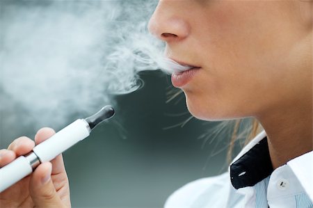 closeup of woman smoking e-cigarette and enjoying smoke. Copy space Foto de stock - Super Valor sin royalties y Suscripción, Código: 400-06926269