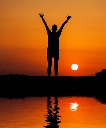 silhouettes of running black girl - Silhouette woman jumping against orange sunset with reflection in water Stock Photo - Budget Royalty-Free & Subscription, Code: 400-06926811