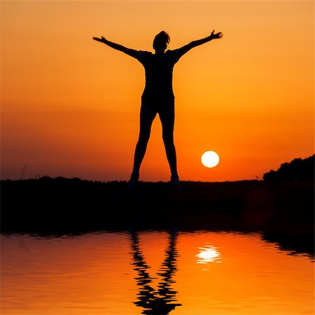dark people running - Silhouette woman jumping against orange sunset with reflection in water Stock Photo - Budget Royalty-Free & Subscription, Code: 400-06926812