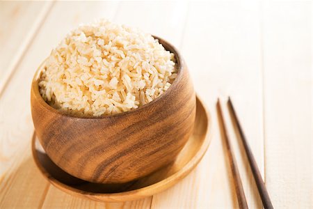 staple - Cooked organic basmati brown rice in wooden bowl with chopsticks on dining table. Foto de stock - Super Valor sin royalties y Suscripción, Código: 400-06927767