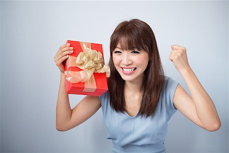 simsearch:400-06477682,k - Asian Girl Holding Gift Box and Smiling happily, cute Asian beauty model, isolated on blue background Stock Photo - Budget Royalty-Free & Subscription, Code: 400-06928027