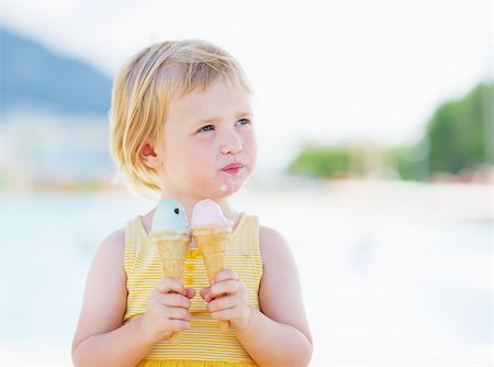 summer ice cream child - Happy baby eating two ice cream horns and looking on copy space Stock Photo - Budget Royalty-Free & Subscription, Code: 400-06928328