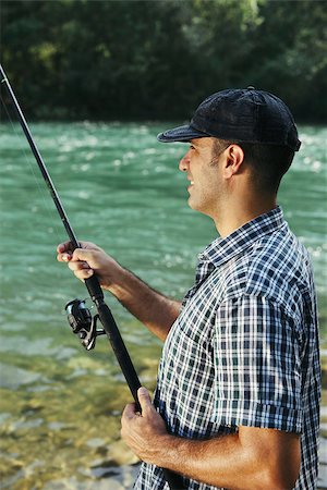 fishing catching equipment - mid adult man on holidays on river, relaxing and fishing trout Stock Photo - Budget Royalty-Free & Subscription, Code: 400-06928801