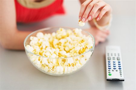 Closeup on teenager girl eating popcorn and watching tv Stock Photo - Budget Royalty-Free & Subscription, Code: 400-06929166