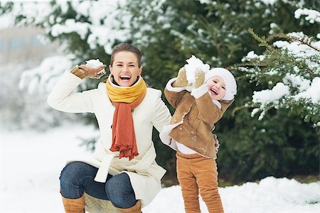 Happy mother and baby throwing snowballs in winter park Stock Photo - Budget Royalty-Free & Subscription, Code: 400-06929511
