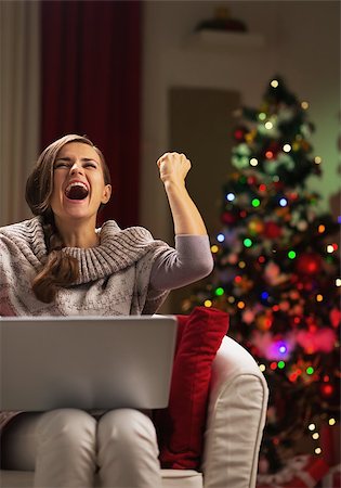 Happy young woman with laptop near christmas tree rejoicing Stock Photo - Budget Royalty-Free & Subscription, Code: 400-06929628
