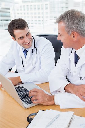 simsearch:614-06898452,k - Doctors working together on laptop in bright office Stock Photo - Budget Royalty-Free & Subscription, Code: 400-06929942