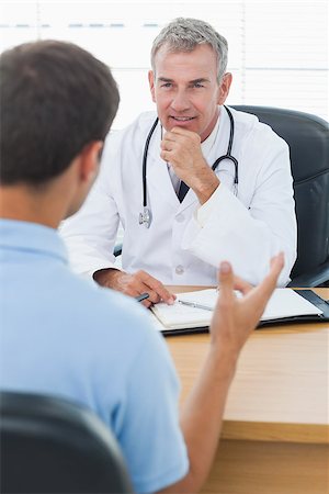 simsearch:614-06898452,k - Attentive doctor listening to his patient in bright surgery Stock Photo - Budget Royalty-Free & Subscription, Code: 400-06929957