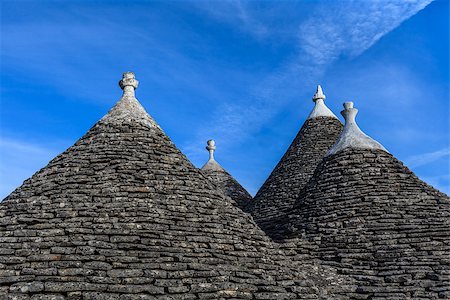 simsearch:862-06677053,k - Roofs of the Trulli houses. Typical historical houses of Alberobello's town. Holiday destination in Apulia. Italy. Stock Photo - Budget Royalty-Free & Subscription, Code: 400-06921495