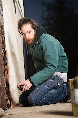 Bearded adult European graffiti artist kneeling on ground Foto de stock - Super Valor sin royalties y Suscripción, Código: 400-06921882