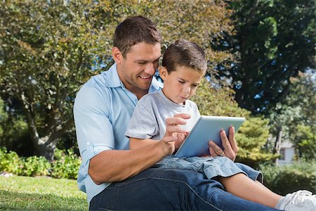 family with tablet in the park - Dad and son using a tablet pc in a park on sunny day Stock Photo - Budget Royalty-Free & Subscription, Code: 400-06934077