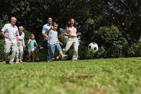 picture of father and son playing foot ball - Cheerful multi generation family playing football in the park Foto de stock - Super Valor sin royalties y Suscripción, Código: 400-06934116