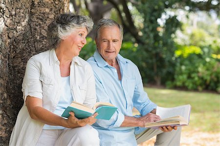 Older couple reading books together sitting on tree trunk at the park on sunny day Stock Photo - Budget Royalty-Free & Subscription, Code: 400-06934151