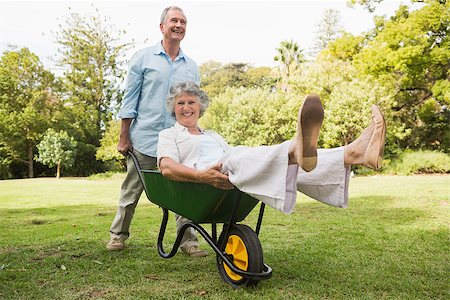 Happy man pushing his laughing wife in a wheelbarrow outside in sunshine Stock Photo - Budget Royalty-Free & Subscription, Code: 400-06934208