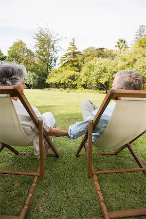 simsearch:693-03304775,k - Happy mature couple holding hands and talking on deck chairs outside Stock Photo - Budget Royalty-Free & Subscription, Code: 400-06934202